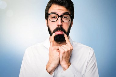 Mavi arka plan gözlüklerle üzgün yakışıklı adam