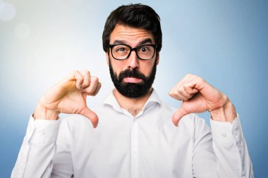 Yakışıklı adam gözlüklü kötü sinyal üzerinde mavi arka plan yapma