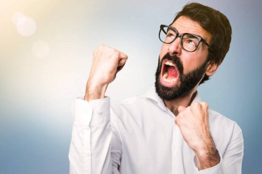 Mavi arka plan üzerinde gözlüklü şanslı yakışıklı adam