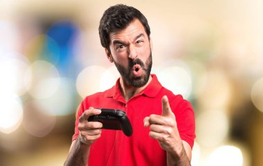 Yakışıklı genç adam bağırıyor ve oyun videogames odaklanmamış arka plan üzerinde