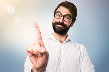 Gözlüklü bir mavi arka plan üzerinde sayma yakışıklı adam