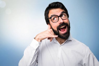 Yakışıklı adamla yapım telefon jest mavi zemin üzerine gözlük