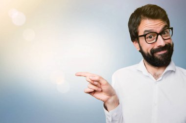 Gözlüklü lateral mavi zemin üzerine işaret eden yakışıklı adam