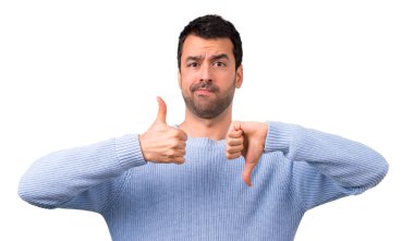 Man with blue sweater making good-bad sign. Undecided person between yes or not clipart