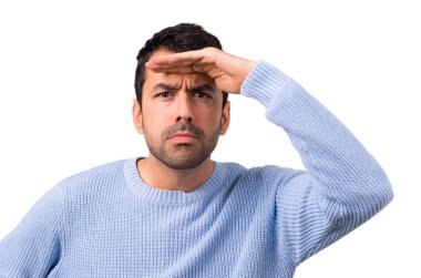 Mavi kazak uzakta el ile seyir ile bir şey aramak için adam