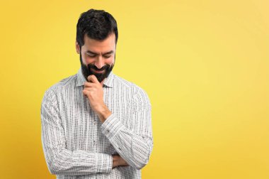 Ayakta ve aşağı bakıyor sakallı yakışıklı adam