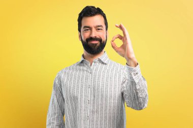 Parmaklar ok işaretiyle gösterilen sakallı yakışıklı adam