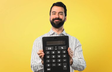 Bir hesap makinesi tutan sakallı yakışıklı adam