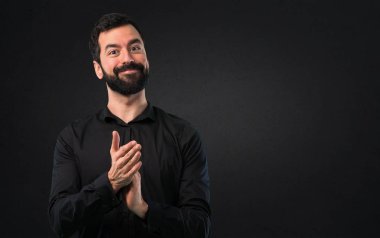 Siyah arka plan üzerine sakal alkış ile yakışıklı adam