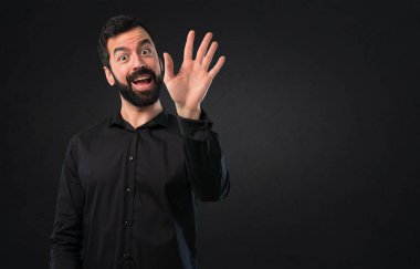 Siyah arka plan üzerine sakal selamlayan ile yakışıklı adam