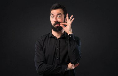 Siyah arka plan üzerine sakal yapma sessizlik hareketi ile yakışıklı adam