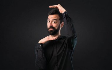 Yüzünü siyah arka plan üzerine odaklanan sakallı yakışıklı adam