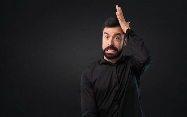 Siyah arka plan üzerine şüpheleri sakallı yakışıklı adam