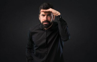 Bir şey siyah arka plan üzerinde gösterilen sakallı yakışıklı adam