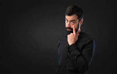 Bir şey siyah arka plan üzerinde gösterilen sakallı yakışıklı adam