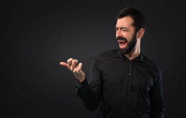 Siyah arka plan üzerine sakal yapma gitar hareketi ile yakışıklı adam