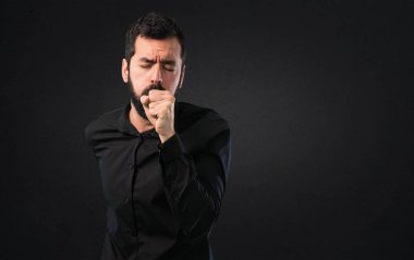 Sakalı çok siyah arka plan üzerine öksürük ile yakışıklı adam