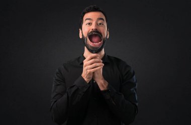 Siyah arka plan üzerine büyüteç ile sakallı yakışıklı adam