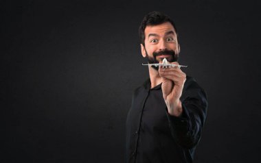 Siyah arka plan üzerine bir oyuncak uçak holding sakallı yakışıklı adam