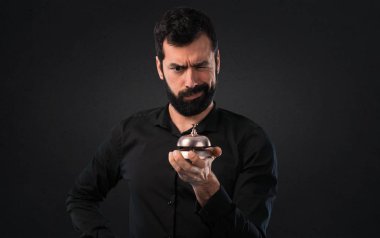 Siyah arka plan üzerine ringbell ile sakallı yakışıklı adam
