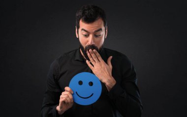 Mutlu yüz simgesi siyah arka plan üzerine tutarak sakallı yakışıklı adam