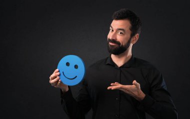 Mutlu yüz simgesi siyah arka plan üzerine tutarak sakallı yakışıklı adam