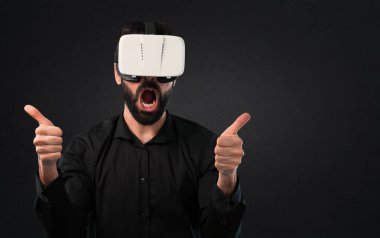 Siyah arka plan üzerine Vr gözlükle sakallı yakışıklı adam