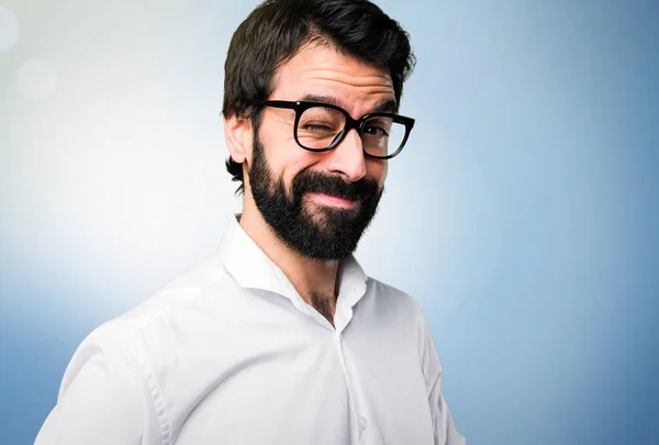 Piscando Bonito Homem Com Óculos Fundo Azul — Fotografia de Stock