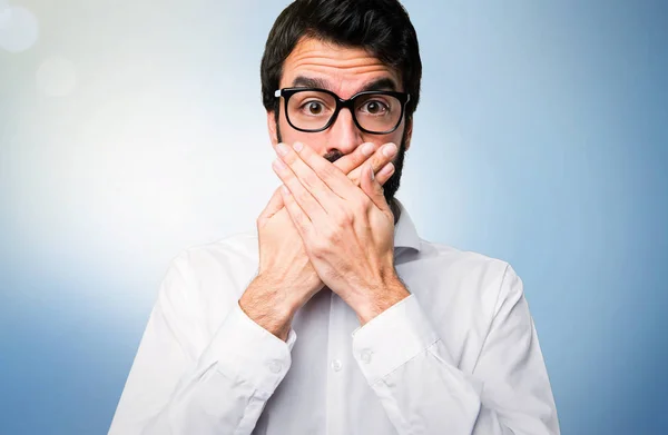 Hombre Guapo Con Gafas Cubriéndose Boca Sobre Fondo Azul —  Fotos de Stock