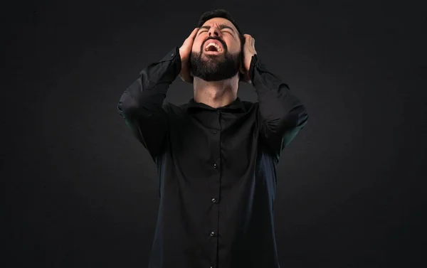 Frustrated handsome man with beard on black background