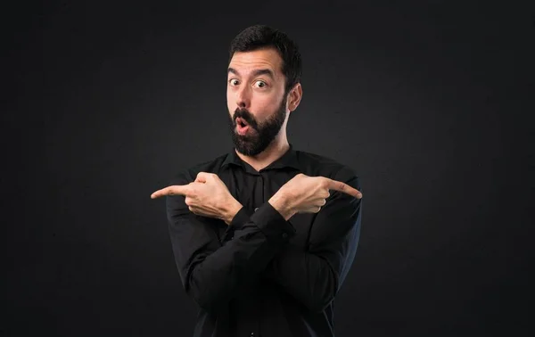 Handsome Man Beard Pointing Laterals Having Doubts Black Background — Stock Photo, Image