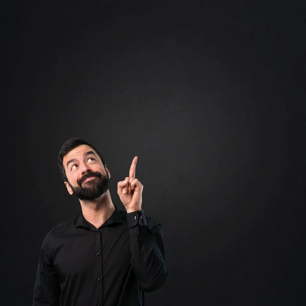 Hombre Guapo Con Barba Apuntando Hacia Arriba Sobre Fondo Negro — Foto de Stock