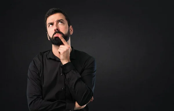 Bonito Homem Com Barba Tendo Dúvidas Sobre Fundo Preto — Fotografia de Stock