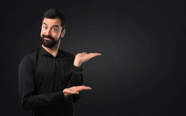 Schöner Mann Mit Bart Präsentiert Etwas Auf Schwarzem Hintergrund — Stockfoto