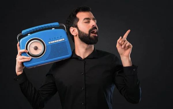 Hombre Guapo Con Barba Sosteniendo Una Radio Sobre Fondo Negro —  Fotos de Stock