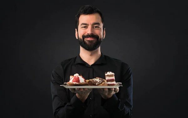 Bonito Homem Com Barba Com Pastelaria Fundo Preto — Fotografia de Stock