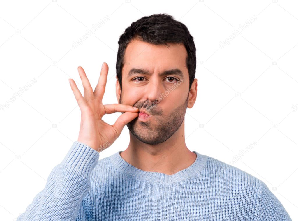Handsome man showing a sign of closing mouth and silence gesture