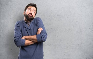 Dokulu arka plan üzerinde önemsiz jest yapma sakallı yakışıklı esmer adam