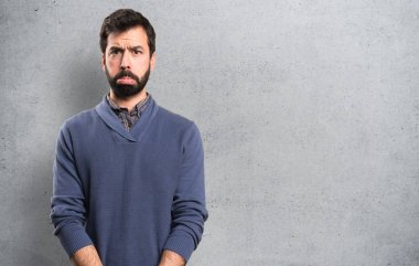 Üzgün yakışıklı esmer adam dokulu arka plan üzerinde sakallı