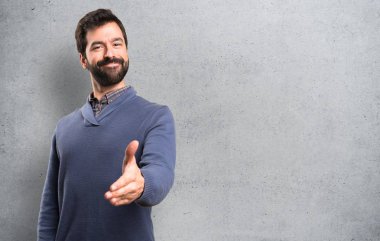 Sakal bir anlaşma üzerinde dokulu arka plan ile esmer yakışıklı