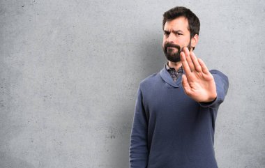 Dur işareti üzerinde dokulu arka plan yapma sakallı yakışıklı esmer adam