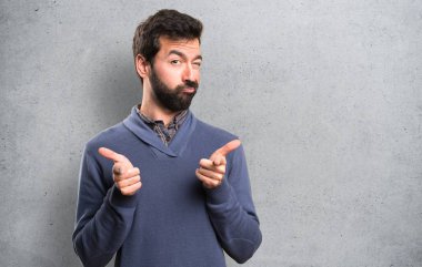 Dokulu arka plan ön işaret eden sakallı yakışıklı esmer adam