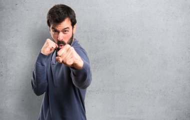 Dokulu arka plan üzerinde mücadele sakallı yakışıklı esmer adam