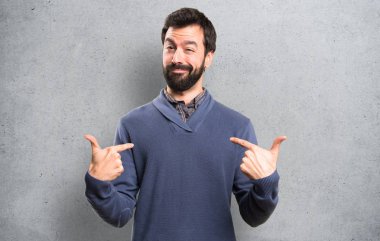 Dokulu arka plan üzerinde kendisiyle gurur sakallı yakışıklı esmer adam