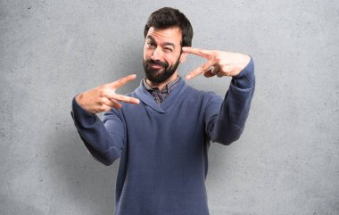 Zafer jest yapma sakallı yakışıklı esmer adam dokulu arka plan