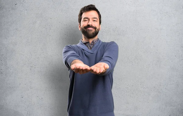 Bonito Morena Homem Com Barba Segurando Algo Fundo Texturizado — Fotografia de Stock