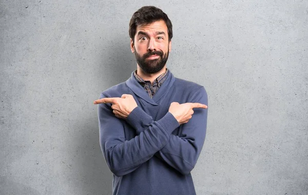 Handsome Brunette Man Beard Pointing Laterals Having Doubts Textured Background — Stock Photo, Image