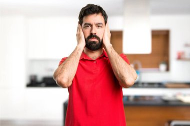 Yakışıklı adam kulakları evin içinde kapsayan