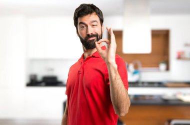 Yakışıklı adam evin içinde oturum Tamam yapma