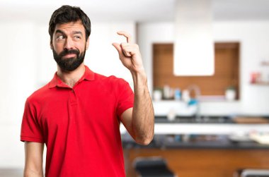 Yakışıklı adam evin içinde küçük işareti yapmak